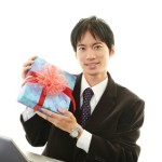 プレゼントを持つ笑顔のビジネスマン